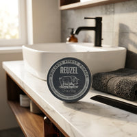 Reuzel Extreme Hold Matte Pomade - gesloten blik op marmeren badkamerwastafel