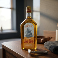 Ed. Pinaud Virgin Island Bay Rum - fles op blad bij het raam naast scheermes