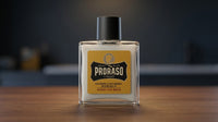 Proraso Beard Balm Wood & Spice - glazen flacon met geel etiket op houten blad