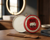 Reuzel Red Pomade - open blik met houten kam ervoor op wastafelblad