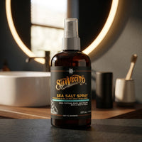 Suavecito Sea Salt Spray - flacon op wastafelblad bij ronde verlichte spiegel
