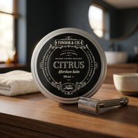 Tonsor & Cie Aftershave Balm Citrus - blik op wastafelblad naast handdoek en scheermes